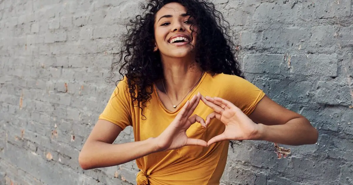 a woman showing the Love hand gesture