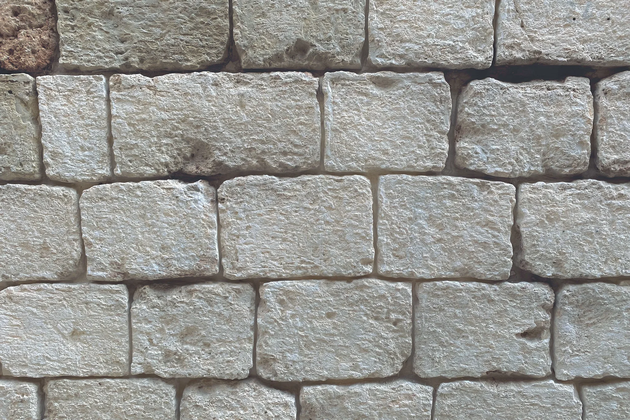 Rows of cut stone blocks fitted into a solid wall. 1111 angel nember in bricks
